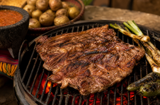Aguja norteña sellada en una parrilla de carbón con papas, jalapeños y salsa molcajeteada.