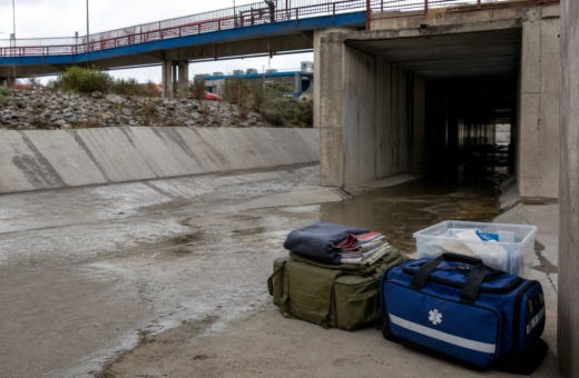 Canalización pluvial de El Bordo en Tijuana con equipo de atención humanitaria visible desde un punto seguro.