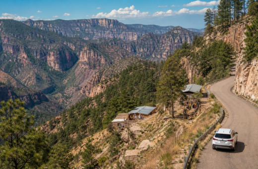 Paisaje de las Barrancas del Cobre en la Sierra Tarahumara con carretera escénica entre montañas.