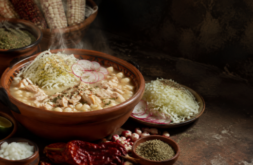 Pozole de maíz cacahuazintle servido en cazuela de barro con col, rábanos, chile y limón, como representación de su raíz mesoamericana.