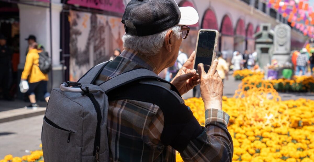 Un visitante fotografía una instalación de flores de cempasúchil en el centro de Toluca.